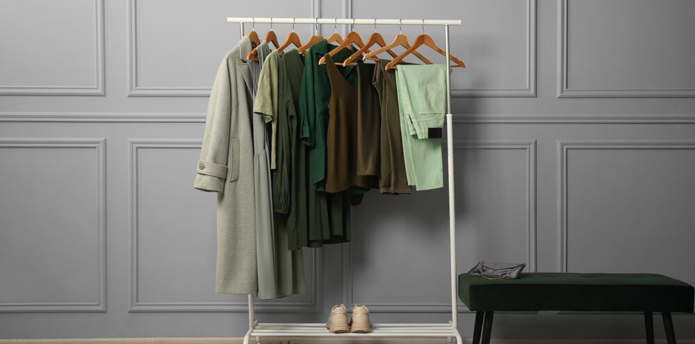 Kledingrek met stijlvolle dameskleding, schoenen en tas, gepresenteerd in een moderne modewinkel.